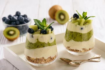 Selbstklebende Fototapeten Healthy food -layered dessert with yogurt, muesli, kiwi and blueberry. © O.B.