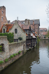 Fototapeta premium View on canal with old picturesque houses with brick and wooden facades in historic part of Bruges (Brugge), Belgium