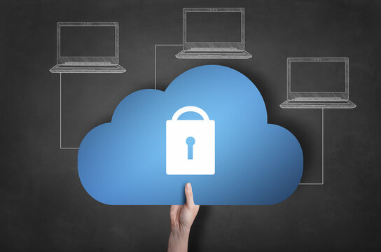 Businessman is holding a blue cloud icon on blackboard. Network security concept.