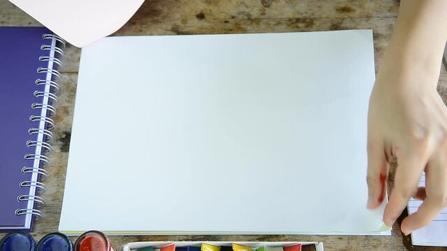 woman opening blank page of many color paper (presentation concept)