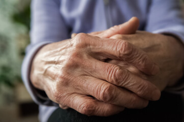 Fototapeta premium Wrinkled hands. The hands of the elderly man hold things in their hands.