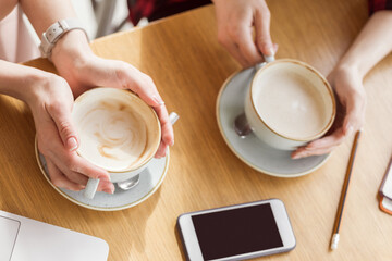 partial view of women drinking coffee on coffee break
