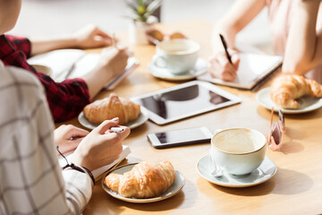 partial view of group of friends study together in cafe