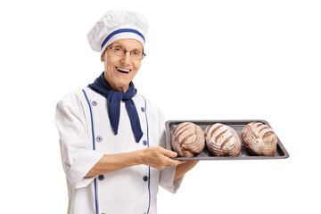 Elderly baker holding a tray with freshly baked breads