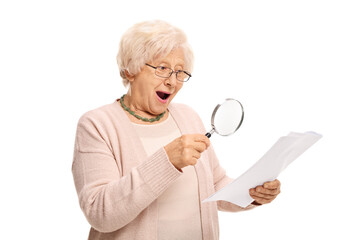 Surprised mature woman looking at a document through magnifying glass