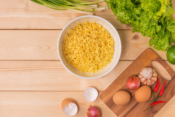 Instant noodles in bowl on wood background