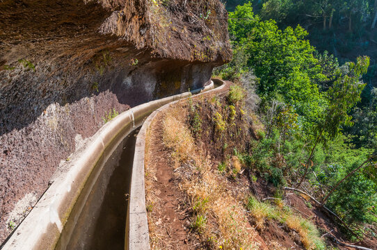 Levada Wanderweg in Madeira durch eine gefr&auml;ste Felswand -  Levada dos Tornos