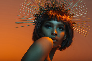 stylish african american girl posing in headpiece with needles