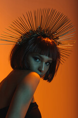 young fashionable african american girl in headpiece with needles looking at camera