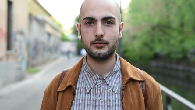Portrait of young man looking camera outdoor &ndash; serene, carefree, pensive concept