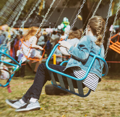 Little girl is riding a carousel in amusement park. © M-Production
