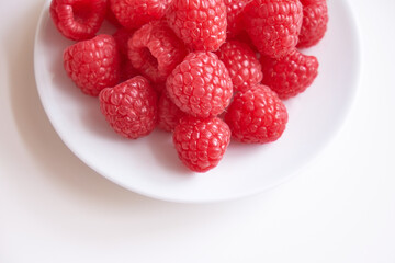 Raspberry on white plate, top view