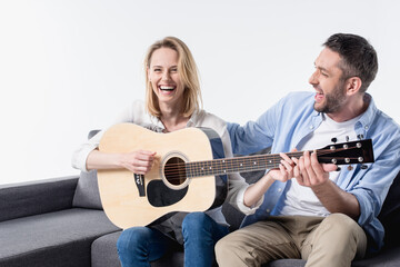 man teaching happy woman playing acoustic guitar isolated on white