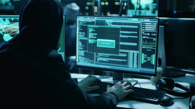 Team of Internationally Wanted Hackers Teem Organize Advanced Virus Attack on Corporate Servers. Place is Dark and Has Multiple displays. Shot on RED EPIC-W 8K Helium Cinema Camera.