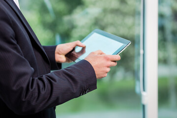 Close up image of business man holding a digital tablet,Portrait of handsome young man working with tablet in the office.Intelligent and confidents businessman holding touch pad with infographics