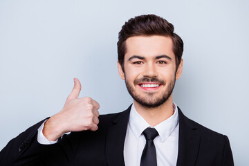 Close up photo of young smart man showing thumb up by recommending his way of running business