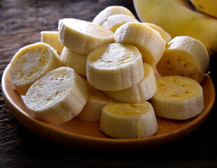 Banana slice in plate wood on table background
