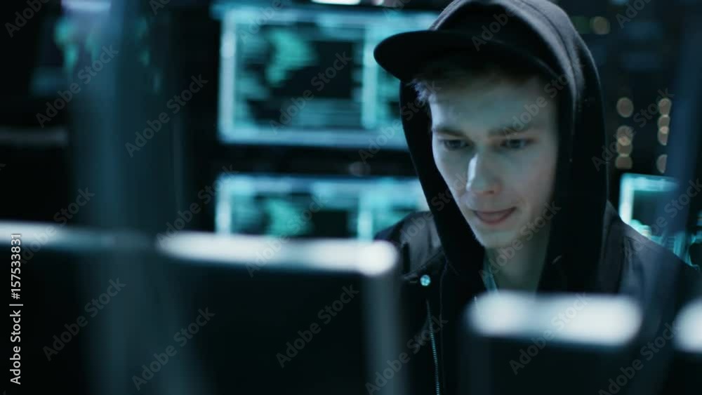 Poster hooded teenage hacker successfully attacks global infrastructure servers with virus. shot on red epi