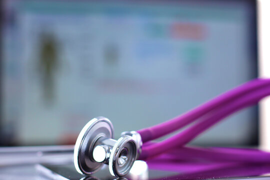 Tablet computer with a stethoscope lie on a table