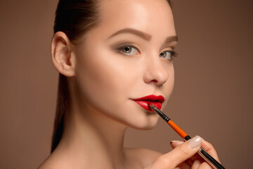 Beautiful female lips with make-up and brush