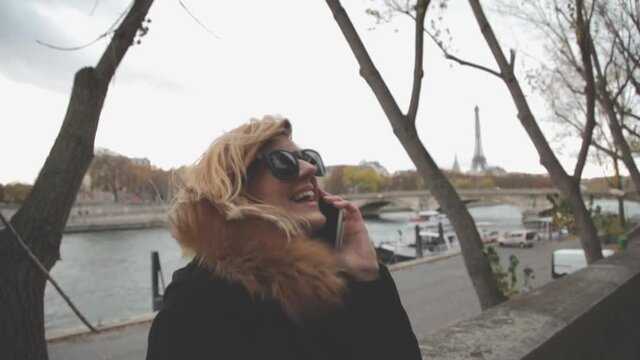 Cute girl using cellphone with Paris background.
