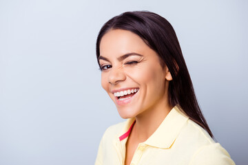 Successful smiling latino girl is winking on light blue background. She has a beaming smile!
