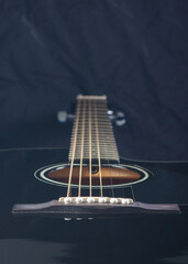 Black acoustic guitar on a black background