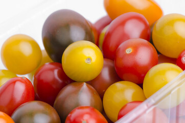 Fototapeta na wymiar Mix Of Different Sorts Cherry Tomatoes On White Background Closeup 