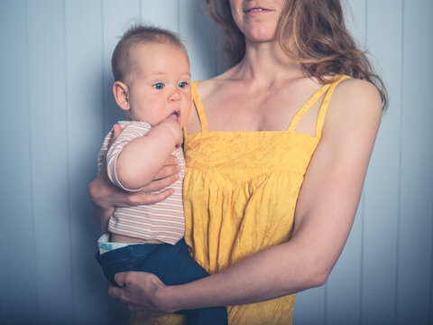 Mother with baby against blue wall