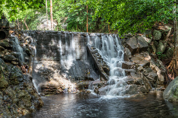 Huai Yang. Small waterfall with water motion in deep rain forest.