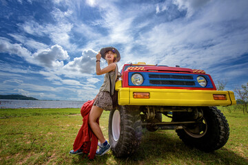 woman enjoy traveling with convertible off road car, sky cleared in background