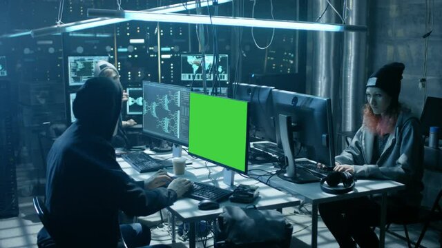 Team of Internationally Wanted Teenage Hackers with Green Screen Mock-up Display Infect Servers and Infrastructure with Virus. Shot on RED EPIC-W 8K Helium Cinema Camera.