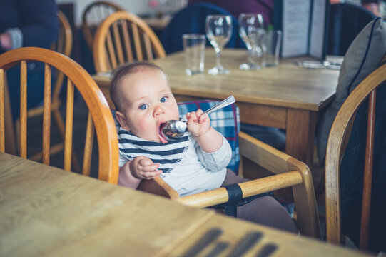 Baby in restaurant with spoon