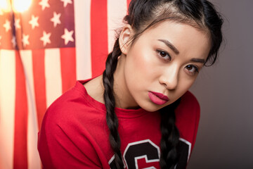Fototapeta premium portrait of young asian woman posing in front of USA flag, Independence Day of America