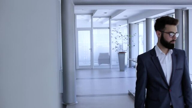Businessman walking and looking trought company modern building