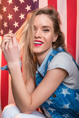 young smiling caucasian woman posing in front of USA flag, Independence Day of America