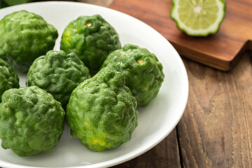 Kaffir lime or lime with white plate on wood

