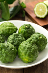 Kaffir lime or lime with white plate on wood

