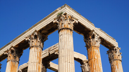 Photo of iconic pillars of Temple of Olympian Zeus with view to the Acropolis and the Parthenon, Athens historic center, Attica, Greece 