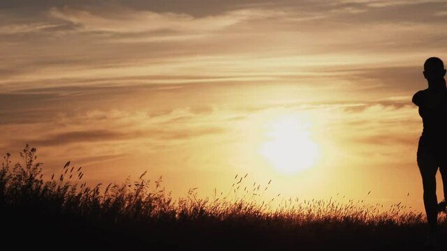 Silhouette runner woman running at sunset Exercising Outdoors. Healthy Lifestyle. Lens Flare. Slow Motion