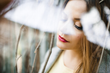 The beautiful  girl stands near branches