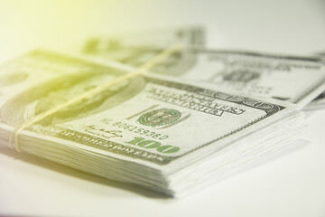 Finance concept. Money stacks. Hundred dollar banknotes isolated on white background. Money concept. Stack growing business. Lens flare in the background.