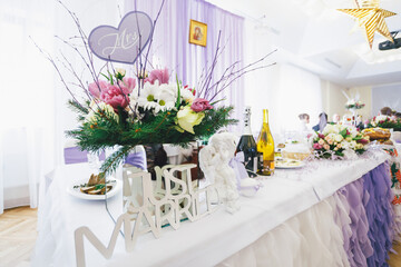 Lettering just married stands before porcelain angel on dinner table