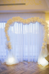 White wedding altar stands before white window