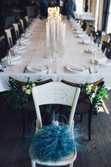 Blue feathers lie on white chair