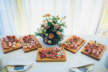 Wooden boards with snacks of fish and meat