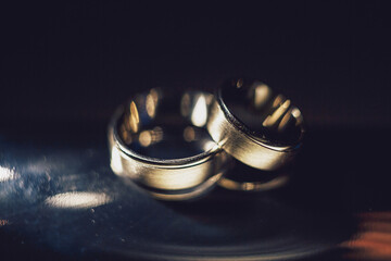 Golden wedding rings lie on mirror table