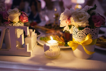 Burning candle stands on rich served dinner table
