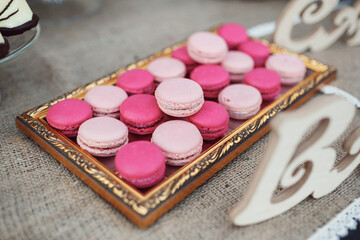Macaroons stand on table covered with hessian cloth