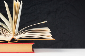 Old books on the table, on a black background, white table